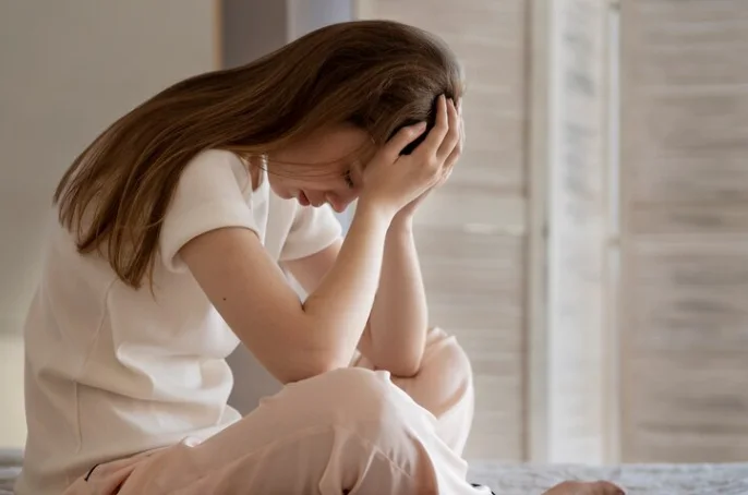 девушка с аутофобией держится за голову